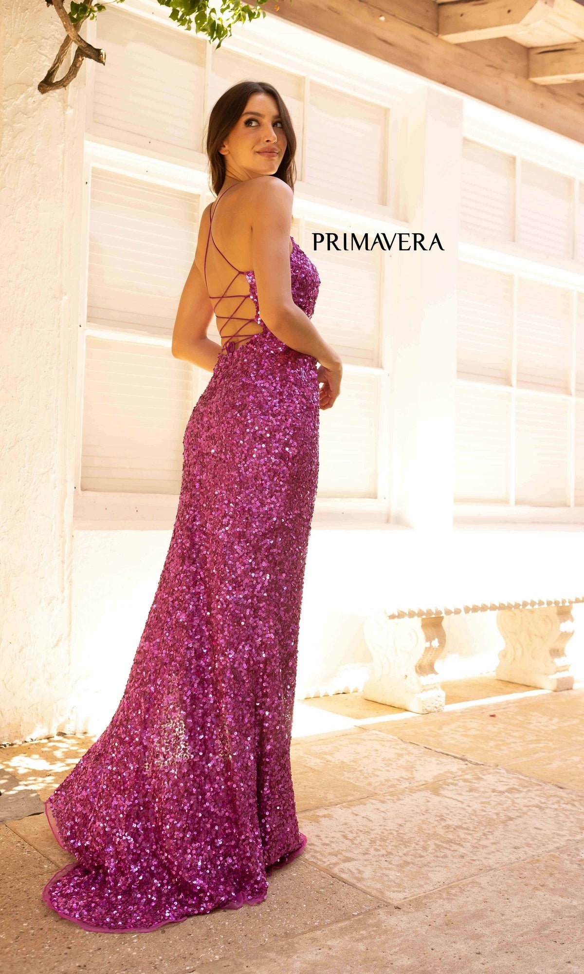 A woman in the Backless Bright Color Long Sequin Prom Dress 3290B stands indoors by white windows, with